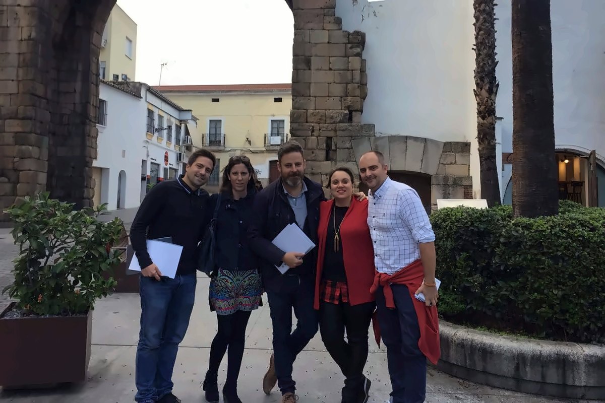 Jorge Villar con un grupo de cuatro personas ante el Arco de Trajano, en Mérida