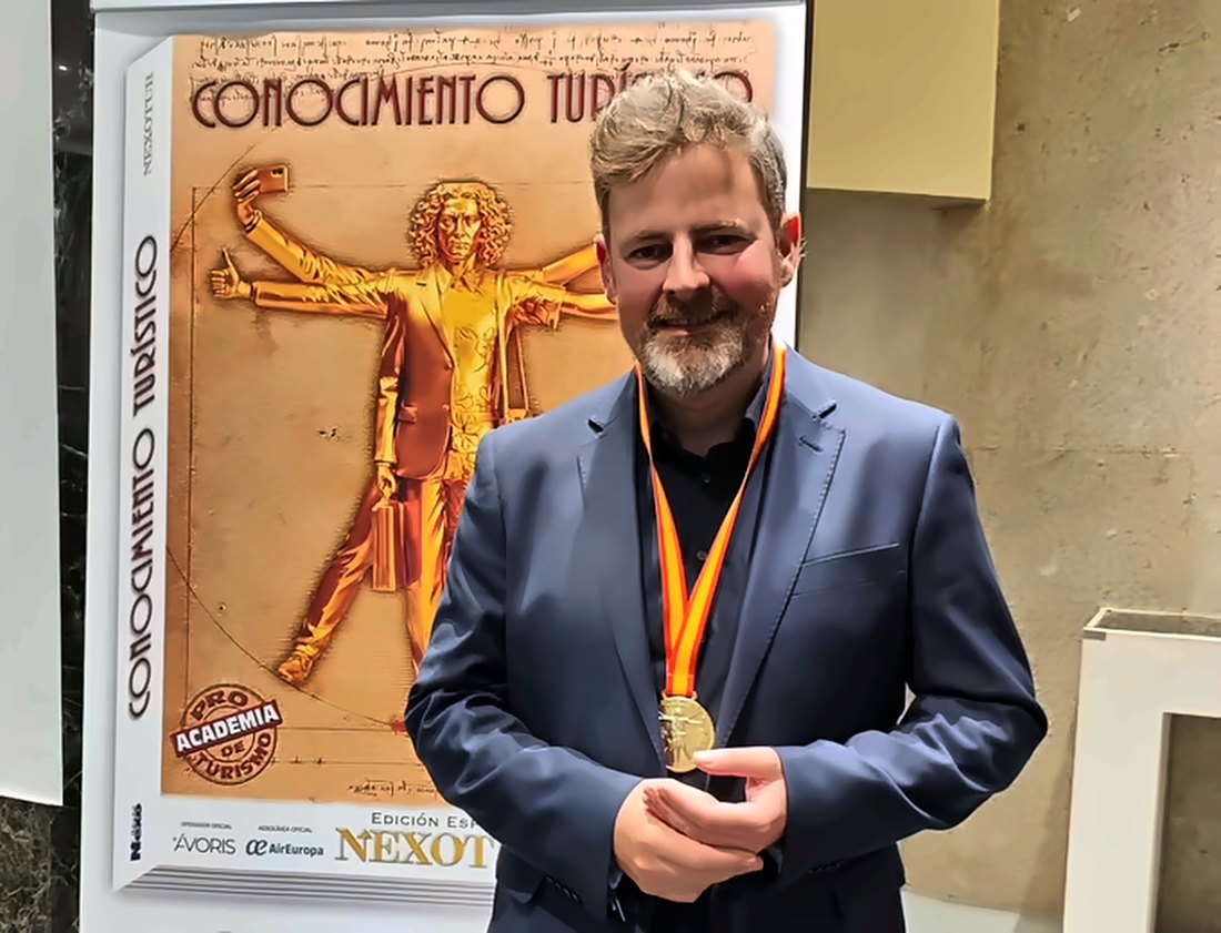 Jorge Villar con la Medalla al Conocimiento Turístico ante el cartel de la obra «Conocimiento Turístico», en la Real Casa de la Moneda